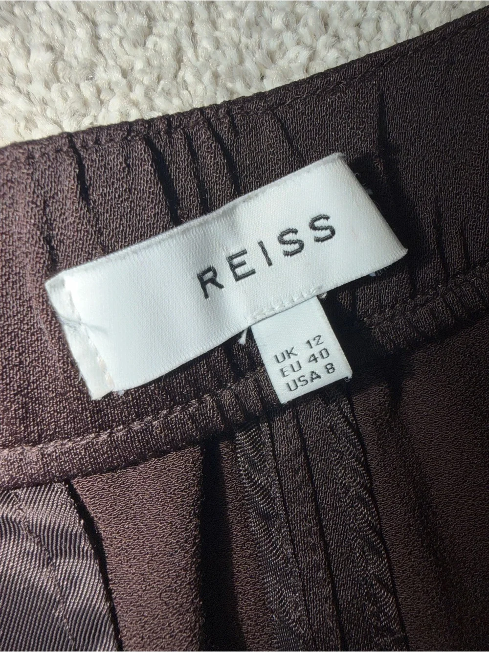 A sleek pair of Reiss women’s trousers in classic black, designed with a comfort